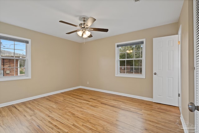 unfurnished room featuring a ceiling fan, baseboards, and light wood-type flooring