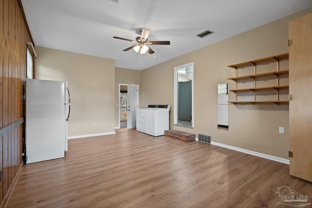 unfurnished living room with visible vents, wood finished floors, washing machine and dryer, and a ceiling fan