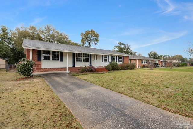 single story home featuring driveway, fence, roof with shingles, a front yard, and brick siding