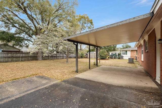 view of yard featuring cooling unit, a patio, an attached carport, and a fenced backyard