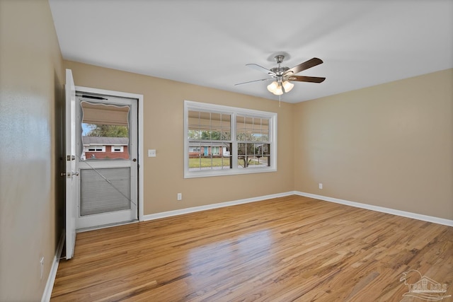 empty room with baseboards, light wood-style floors, and a ceiling fan