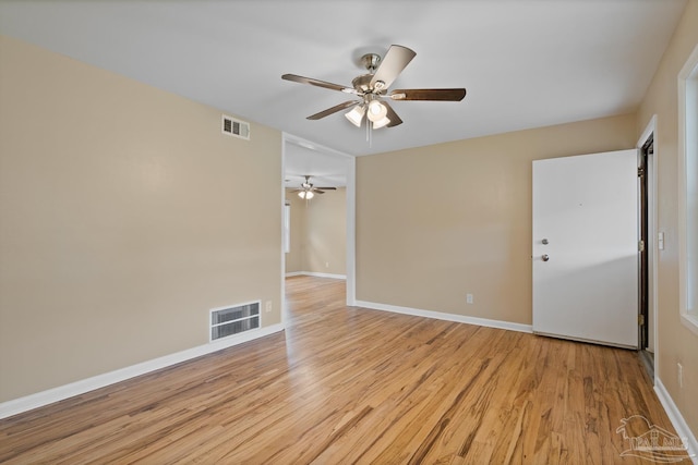 unfurnished room with light wood-type flooring, visible vents, baseboards, and ceiling fan