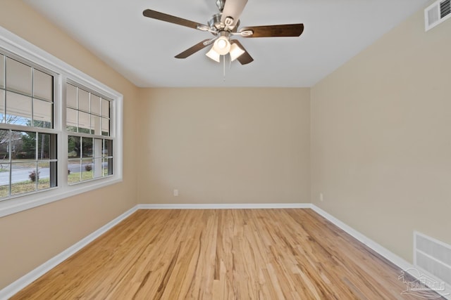 empty room with a ceiling fan, baseboards, visible vents, and light wood-type flooring