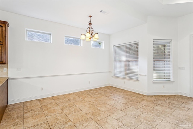 unfurnished dining area featuring a notable chandelier and a wealth of natural light