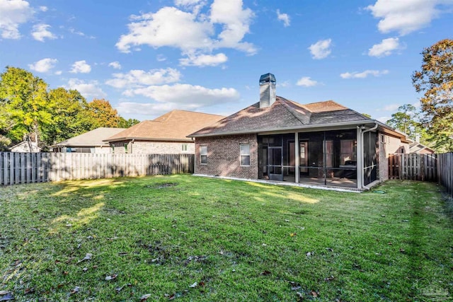 back of property featuring a sunroom and a yard