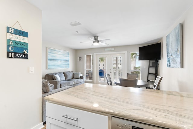 kitchen featuring french doors, dishwasher, ceiling fan, light stone countertops, and white cabinets