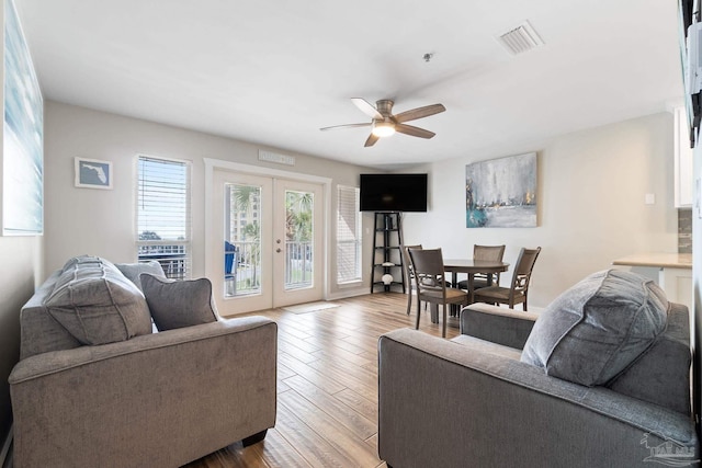 living room with ceiling fan, light hardwood / wood-style floors, and french doors