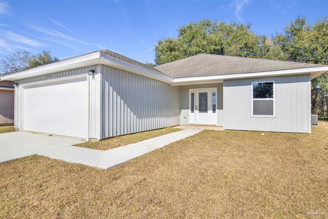 ranch-style house with a garage, central air condition unit, and a front lawn