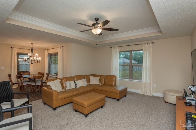 living room featuring ceiling fan with notable chandelier, a textured ceiling, a raised ceiling, and carpet