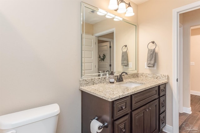 bathroom featuring hardwood / wood-style flooring, vanity, and toilet