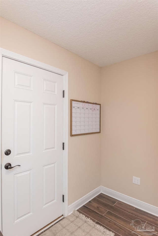 unfurnished room featuring hardwood / wood-style floors and a textured ceiling