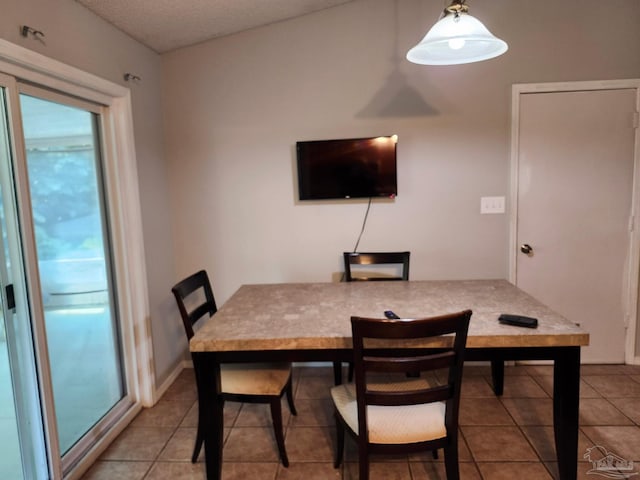 dining room featuring tile patterned flooring and a textured ceiling