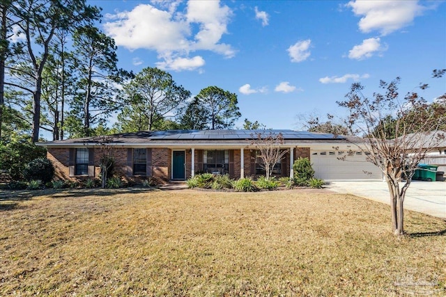 ranch-style home featuring a garage, a front yard, and solar panels