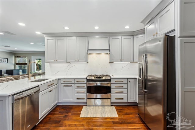 kitchen featuring stainless steel appliances, sink, kitchen peninsula, light stone counters, and gray cabinetry