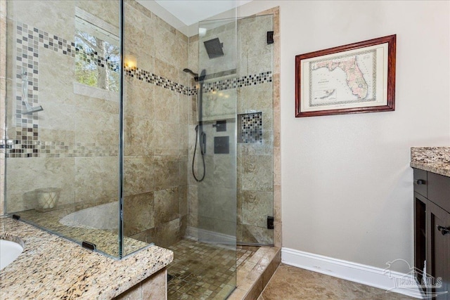 bathroom with vanity, tiled shower, and tile patterned flooring