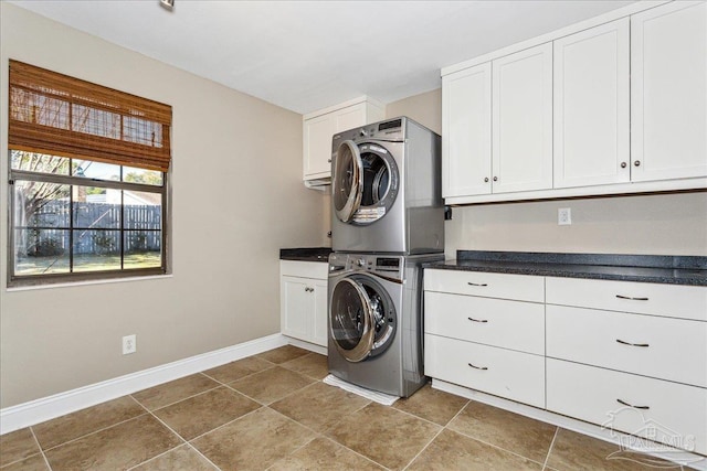 laundry room with cabinets and stacked washer and clothes dryer