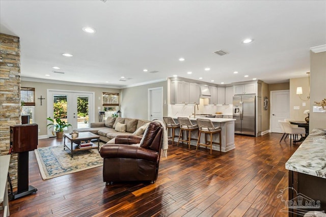 living room with sink, french doors, crown molding, and dark hardwood / wood-style flooring