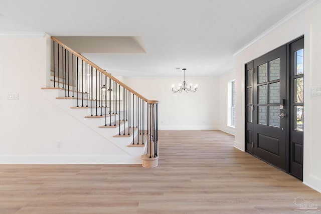 entryway featuring baseboards, light wood finished floors, stairs, crown molding, and a chandelier