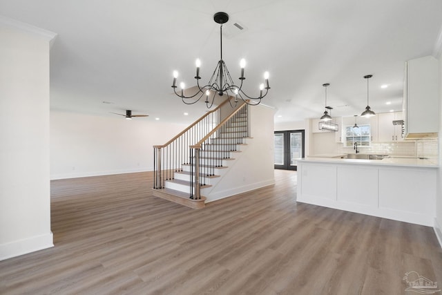 kitchen featuring light wood-style flooring, open floor plan, light countertops, and white cabinetry