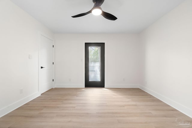 empty room featuring baseboards, a ceiling fan, and light wood finished floors