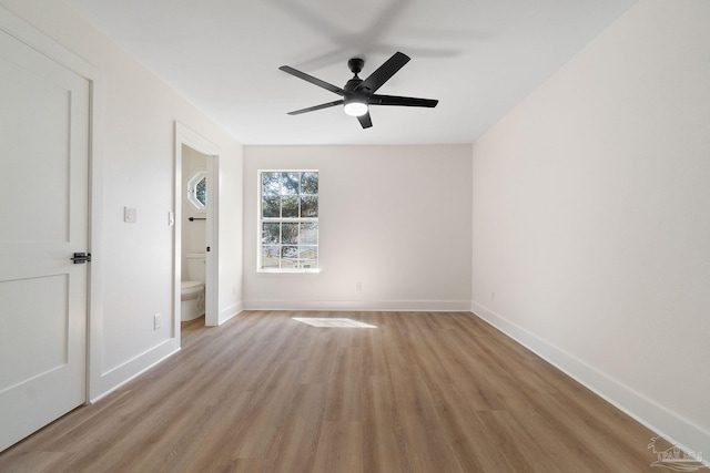 spare room featuring light wood-style flooring, baseboards, and ceiling fan