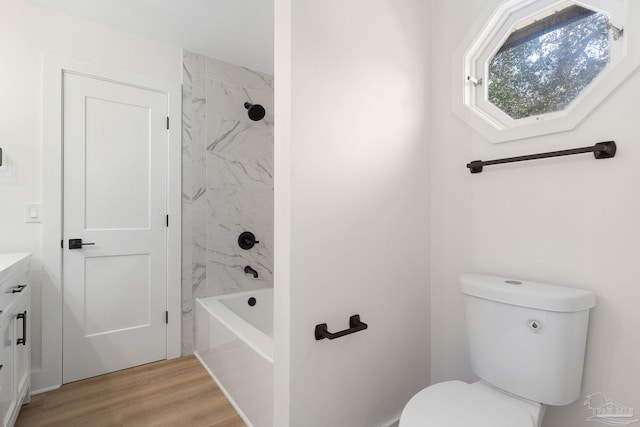 bathroom featuring vanity, bathing tub / shower combination, toilet, and wood finished floors