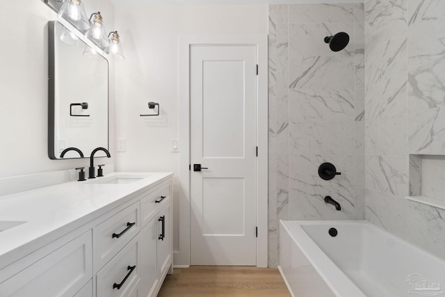 full bath featuring double vanity, shower / washtub combination, wood finished floors, and a sink