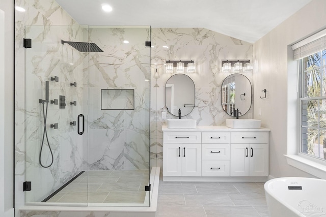 bathroom with double vanity, a soaking tub, a marble finish shower, and a sink