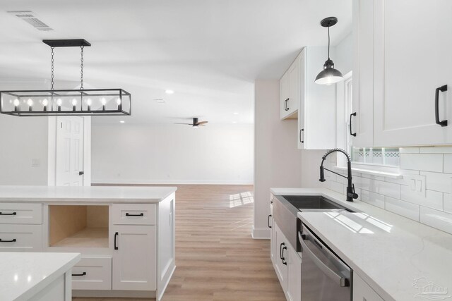 kitchen featuring light wood finished floors, visible vents, dishwasher, white cabinets, and a sink