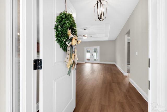 foyer entrance featuring french doors, a tray ceiling, and dark hardwood / wood-style floors