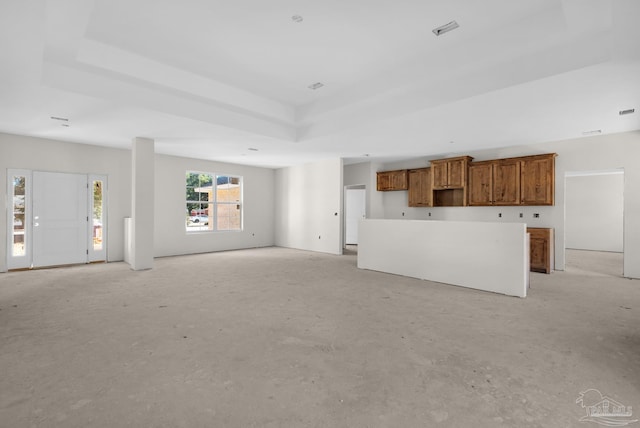 unfurnished living room with a raised ceiling