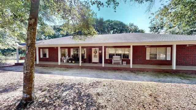 rear view of property with covered porch and brick siding