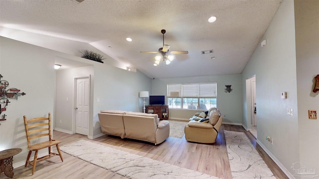 living room featuring visible vents, a ceiling fan, vaulted ceiling, a textured ceiling, and light wood-type flooring