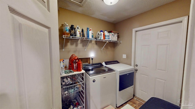 laundry room with light hardwood / wood-style floors, separate washer and dryer, and a textured ceiling