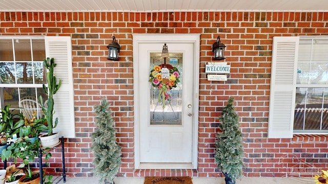 entrance to property featuring brick siding