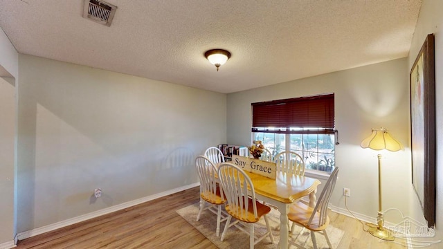 dining area featuring hardwood / wood-style floors and a textured ceiling