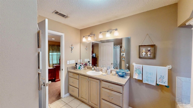 bathroom featuring tile patterned floors, vanity, and a textured ceiling