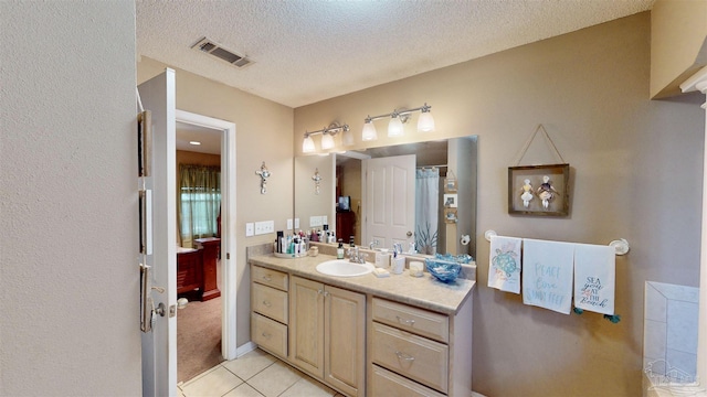 full bath featuring tile patterned floors, visible vents, a textured ceiling, and vanity