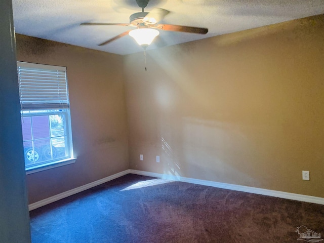 carpeted spare room with ceiling fan and a textured ceiling