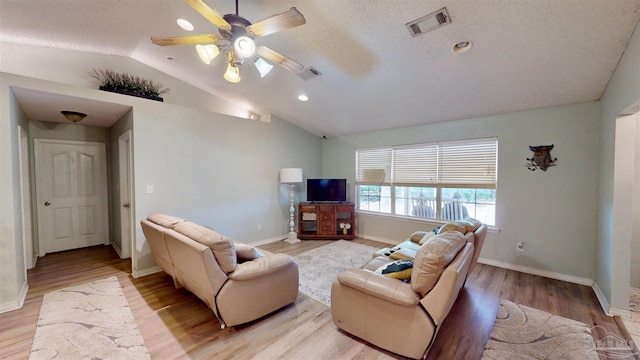 living room featuring a textured ceiling, ceiling fan, lofted ceiling, and light wood-type flooring