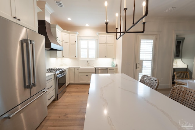 800 N Baylen St, Pensacola, FL 32501 - kitchen with appliances with stainless steel finishes, light wood-style flooring, crown molding, a sink, and white cabinetry