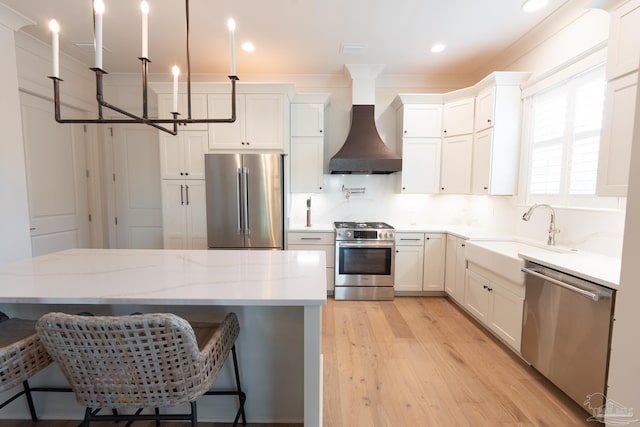 800 N Baylen St, Pensacola, FL 32501 - kitchen featuring stainless steel appliances, custom exhaust hood, a sink, light wood-style flooring, and white cabinetry