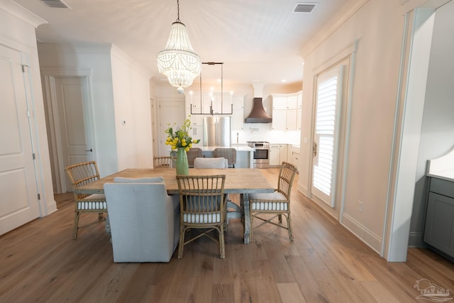 800 N Baylen St, Pensacola, FL 32501 - dining space featuring a chandelier, light wood-style floors, and baseboards