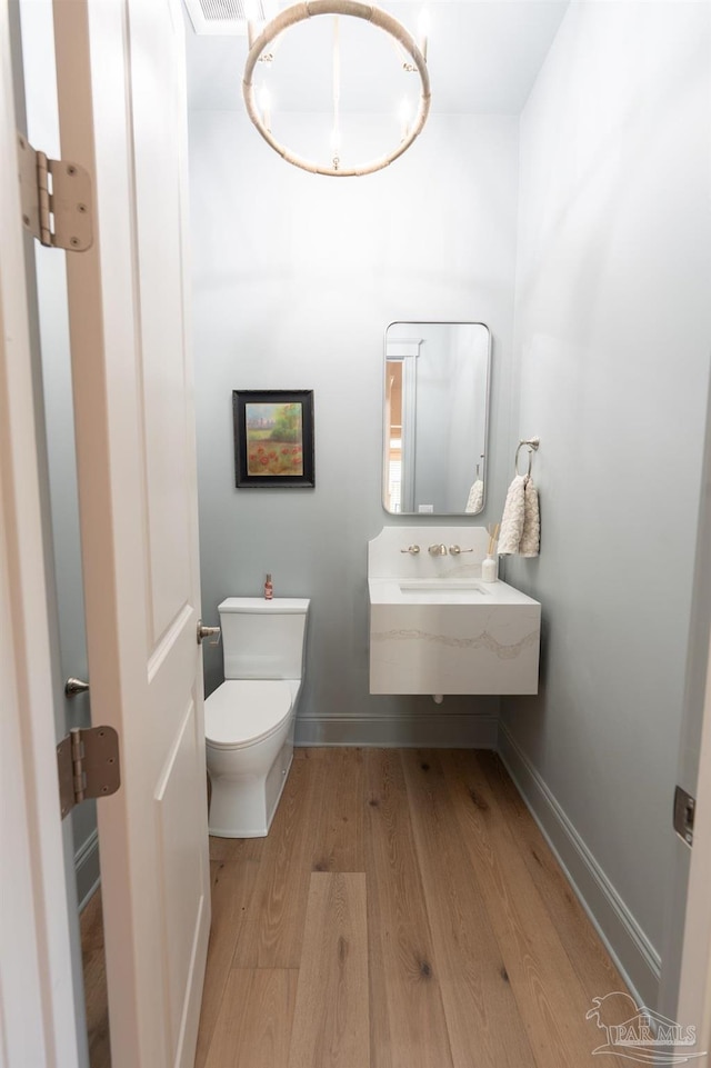 800 N Baylen St, Pensacola, FL 32501 - bathroom with wood finished floors, baseboards, toilet, and a sink