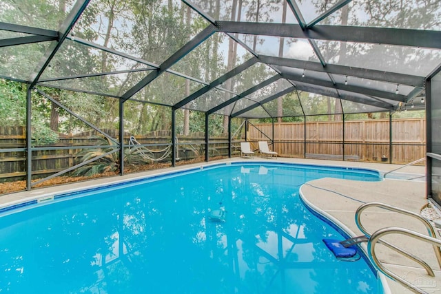 view of swimming pool with a lanai, a fenced in pool, a patio, and a fenced backyard