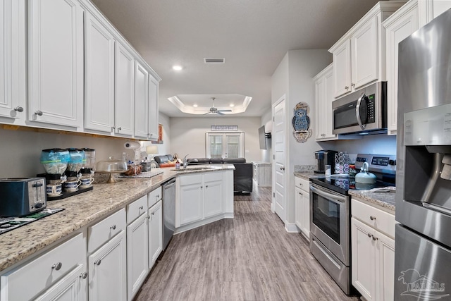 5323 Red Shoulder Rd, Pace, FL 32571 - kitchen featuring stainless steel appliances, ceiling fan, a sink, a raised ceiling, and white cabinets