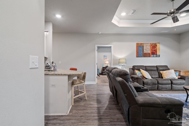 5323 Red Shoulder Rd, Pace, FL 32571 - living area featuring dark wood-style floors, crown molding, a ceiling fan, a tray ceiling, and baseboards