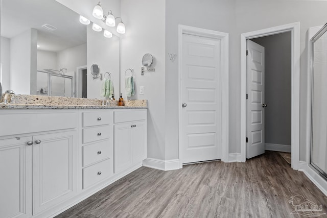 5323 Red Shoulder Rd, Pace, FL 32571 - full bath featuring a shower stall, double vanity, wood finished floors, and baseboards