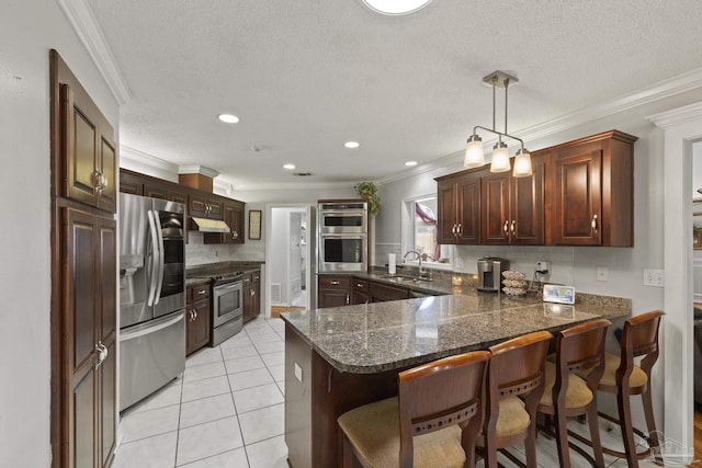 kitchen with stainless steel appliances, decorative light fixtures, sink, and kitchen peninsula