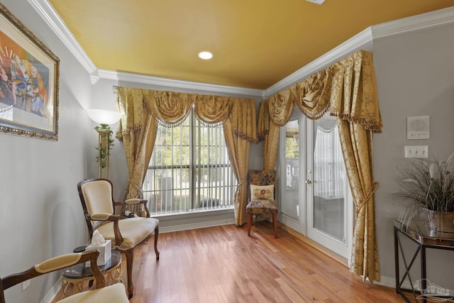 sitting room featuring ornamental molding and wood-type flooring